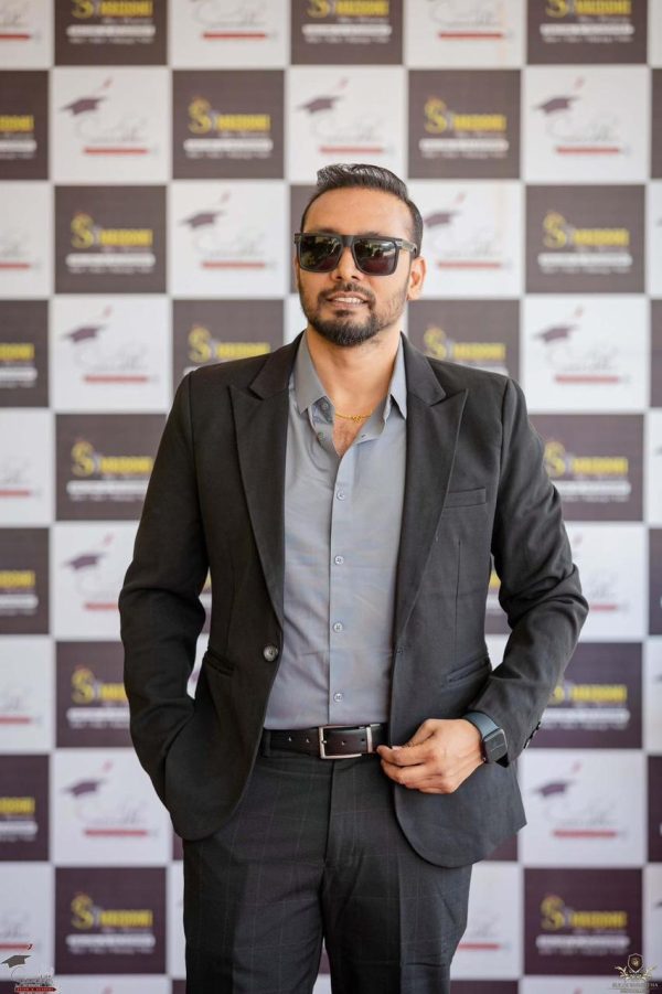 a tall dark man wearing sunglasses and formal black outfits